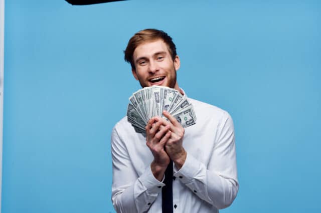 Cheerful man with bundles of money wealth emotion joy