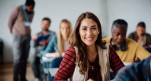 Etudiante heureuse de rédiger une lettre de motivation pour intégrer une école
