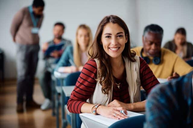 Etudiante heureuse de rédiger une lettre de motivation pour intégrer une école