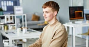 Jeune homme satisfait d'avoir écrit sa lettre de motivation pour un emploi