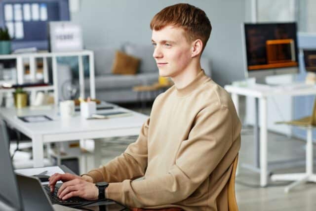 Jeune homme satisfait d'avoir écrit sa lettre de motivation pour un emploi Jeune homme satisfait d'avoir écrit sa lettre de motivation pour un emploi