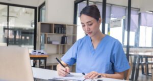 Jeune femme qui est heureuse de rédiger sa lettre de motivation pour être infirmière