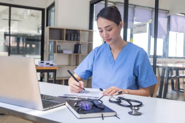Jeune femme qui est heureuse de rédiger sa lettre de motivation pour être infirmière