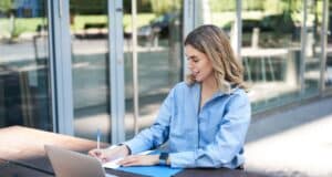 Jeune salariée qui rédige un lettre de motivation spontanée pour trouver un travail