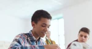 Un collégien heureux de rédiger sa lettre de motivation pour son stage de 3ème