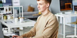 Jeune homme satisfait d'avoir écrit sa lettre de motivation pour un emploi